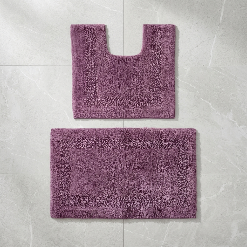 Aubergine Brillare cotton bath mat and pedestal mat styled on a light marble tiled floor showing loop and bobble pile with silver sparkle border trim Emma Barclay Panache Home