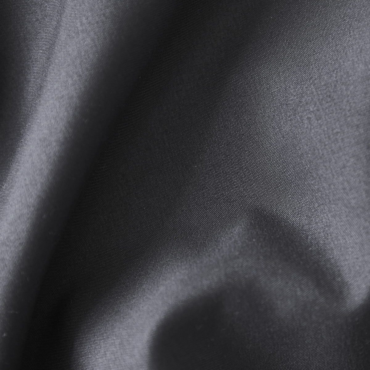 Close-up of black soft-touch 100% polyester fabric, non-iron, quick-dry texture