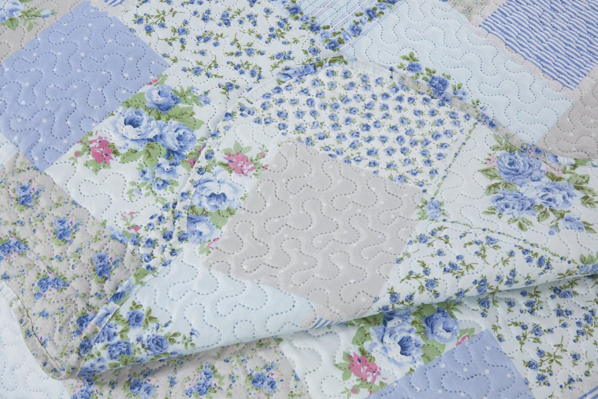 Close up of blue quilted patchwork floral fabric texture with scalloped edge detail