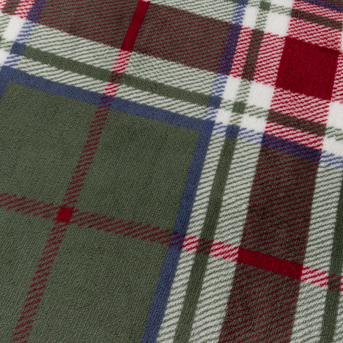 Close-up detail of the tartan check print showing pine green squares bordered in navy blue, with red and white stripe lines crossing through the fabric weave – Kumperi