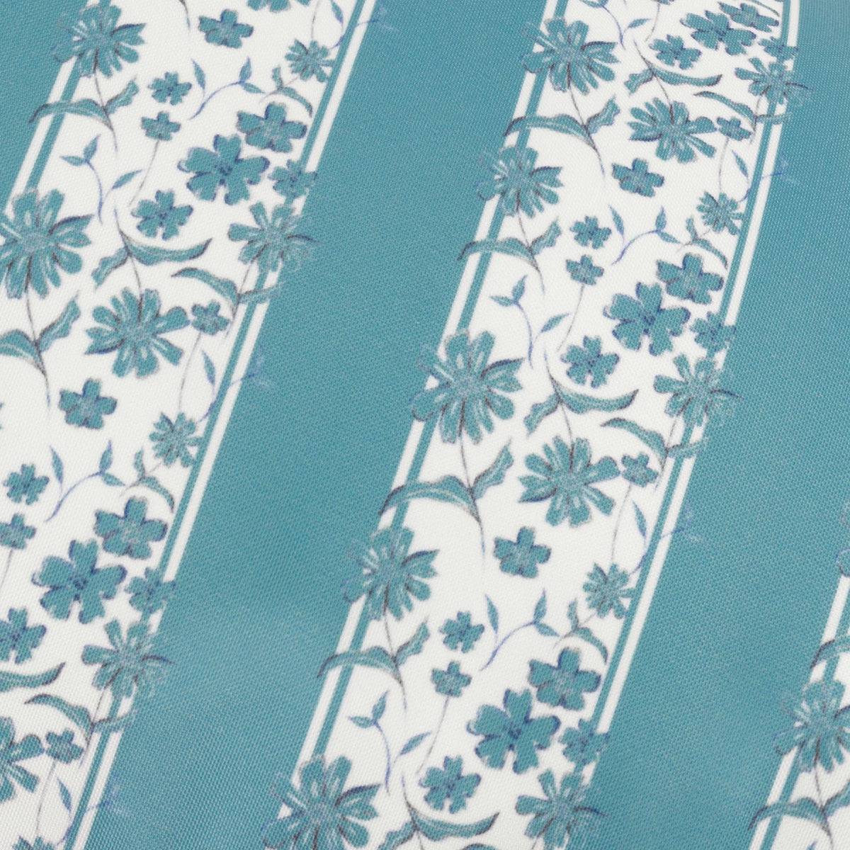 Close-up detail of the printed fabric showing teal floral vines with delicate petals and leaves alternating with plain teal stripes on a white ground – Kumperi