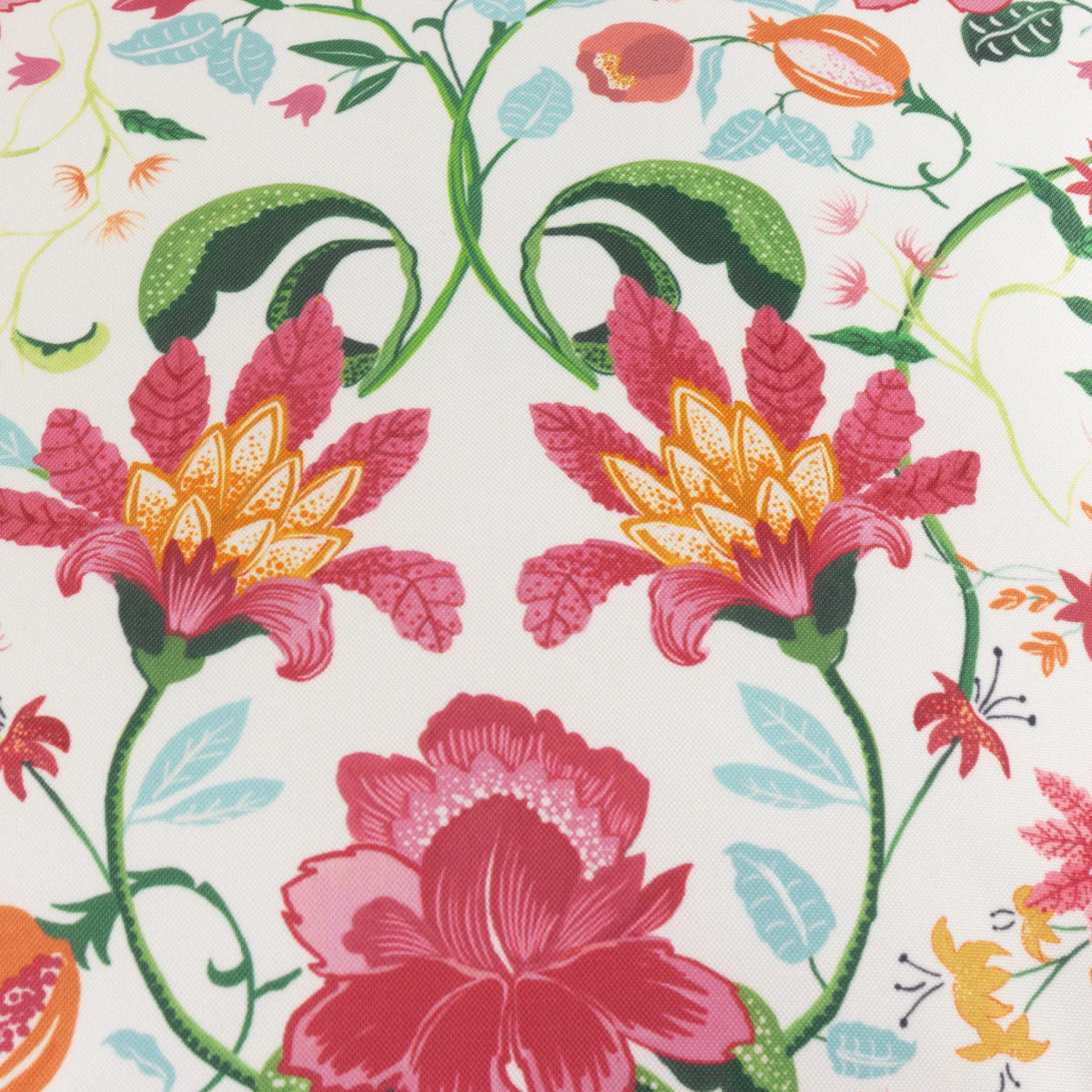 Close-up detail of the floral print showing large red and pink flowers, orange pomegranates, pale blue leaves and delicate yellow blossoms on a white ground – Kumperi