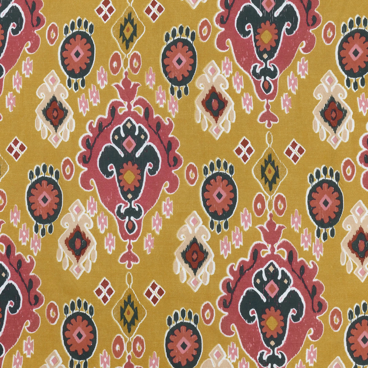 Close-up flat detail of the amber Ikat print showing pink and black medallion motifs, sunburst rosettes, small diamond clusters and Aztec-style diamond accents – Kumperi