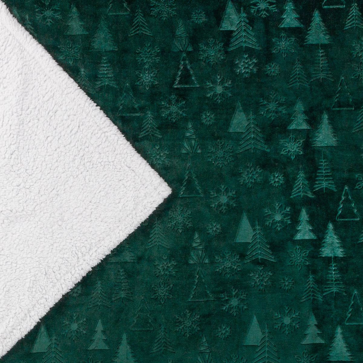 Corner of the throw folded back to reveal the white sherpa fleece reverse against the embossed emerald tree and snowflake pattern – Kumperi