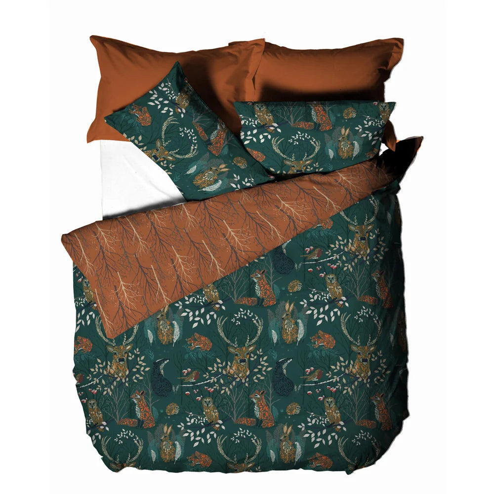 Flat top-down view of the folded duvet cover and pillowcases showing both reversible sides together, the emerald woodland animal print and the rust branch pattern – Kumperi