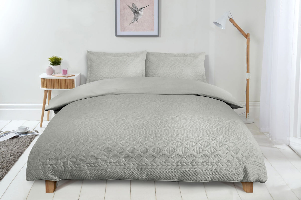 Silver luxury quilted embossed duvet cover set styled on a neatly made double bed