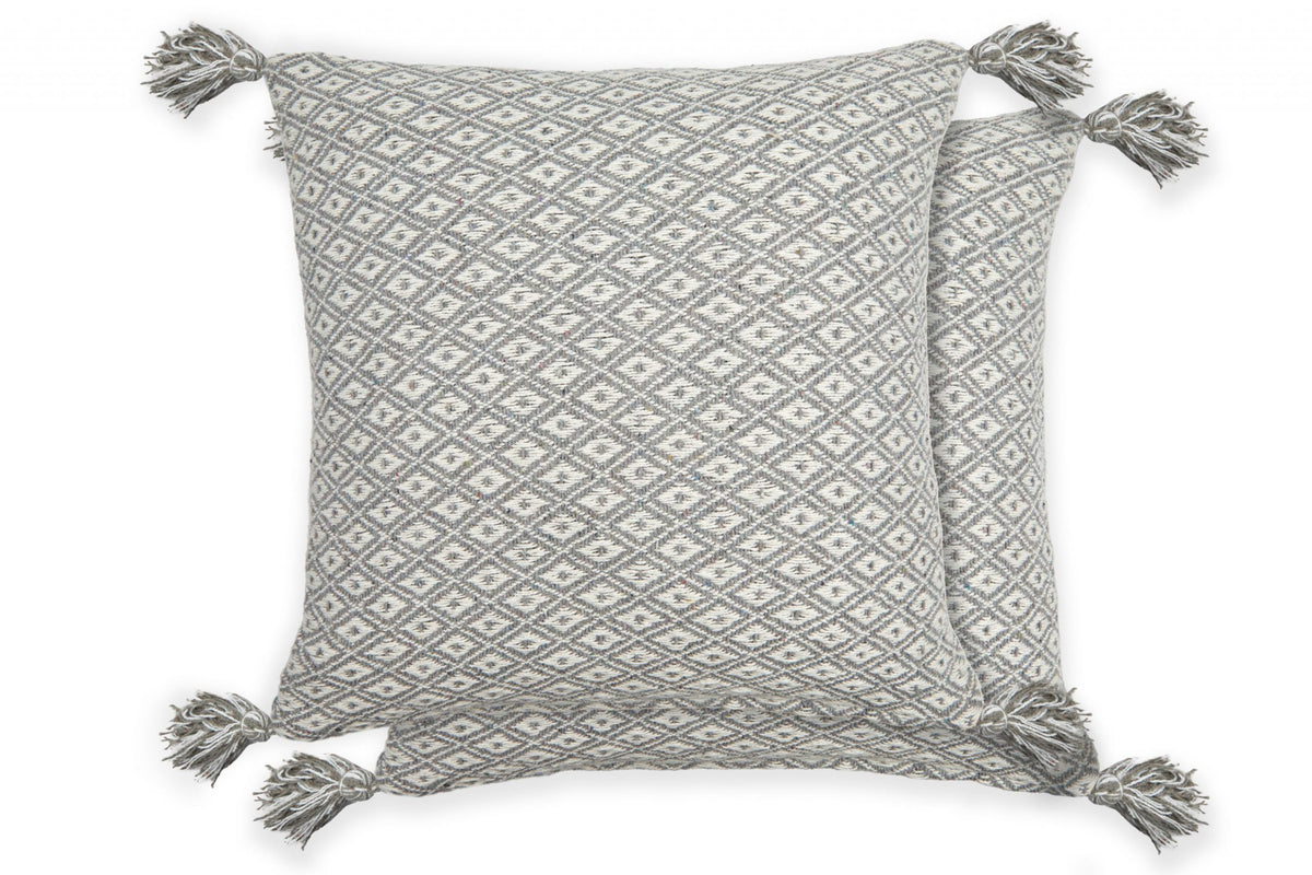 Two silver-grey and white diamond weave cushion covers with tassels on white background, Kumperi