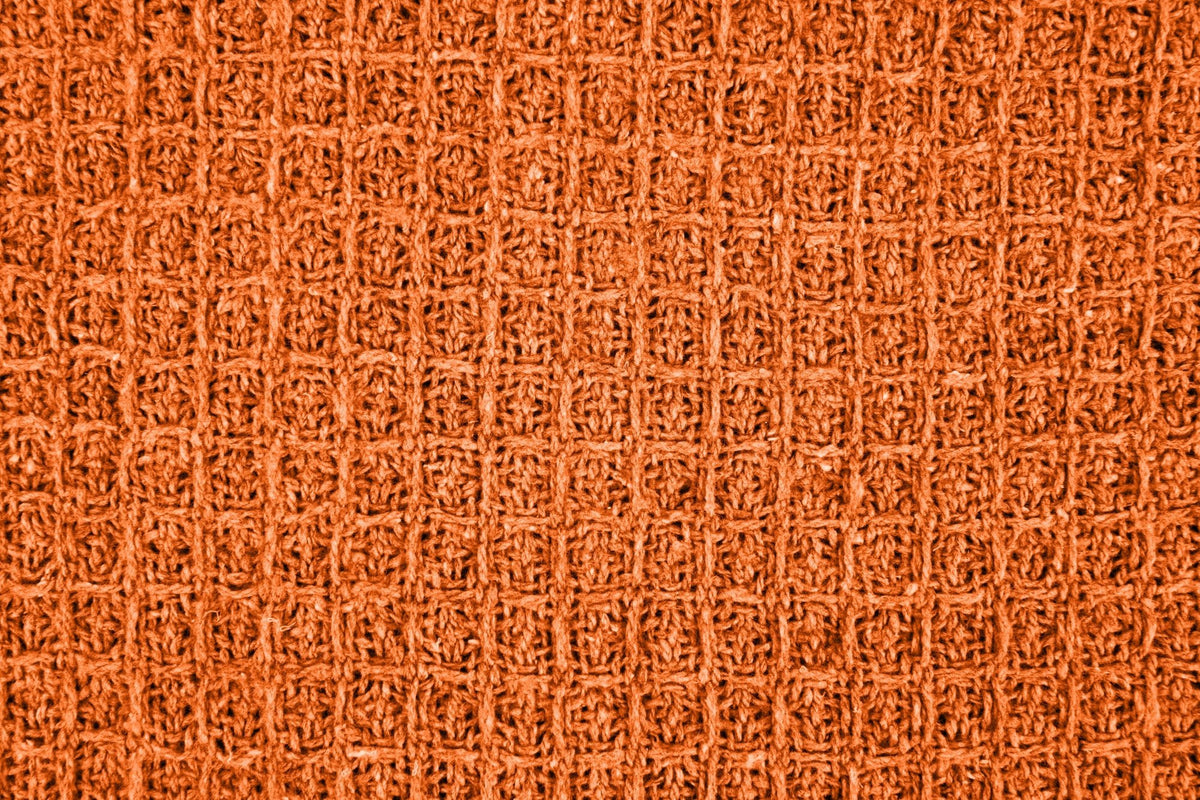 Close-up macro shot of burnt orange honeycomb weave fabric texture, Kumperi