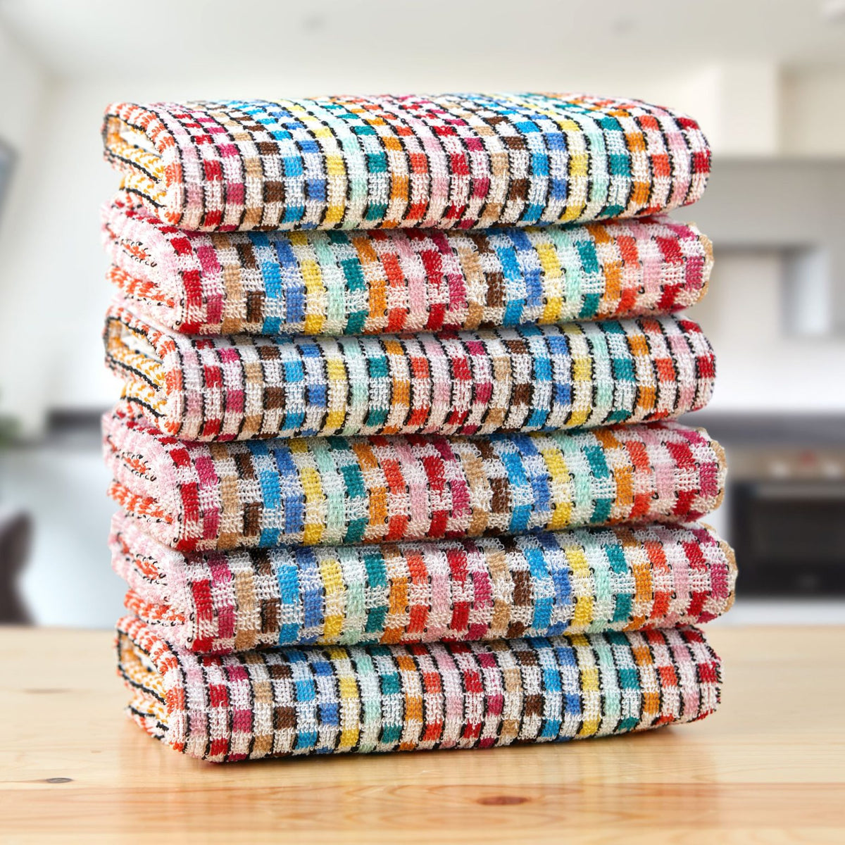 Stack of 6 multicoloured woven check tea towels on wooden kitchen counter, Jazz design, Kumperi