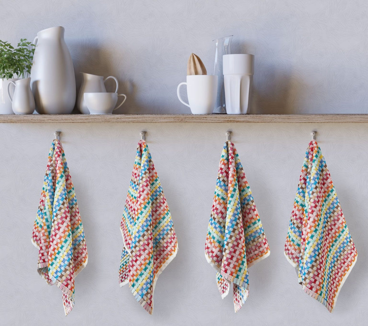 Four multicoloured woven check tea towels hanging on kitchen hooks below shelf, Jazz design, Kumperi