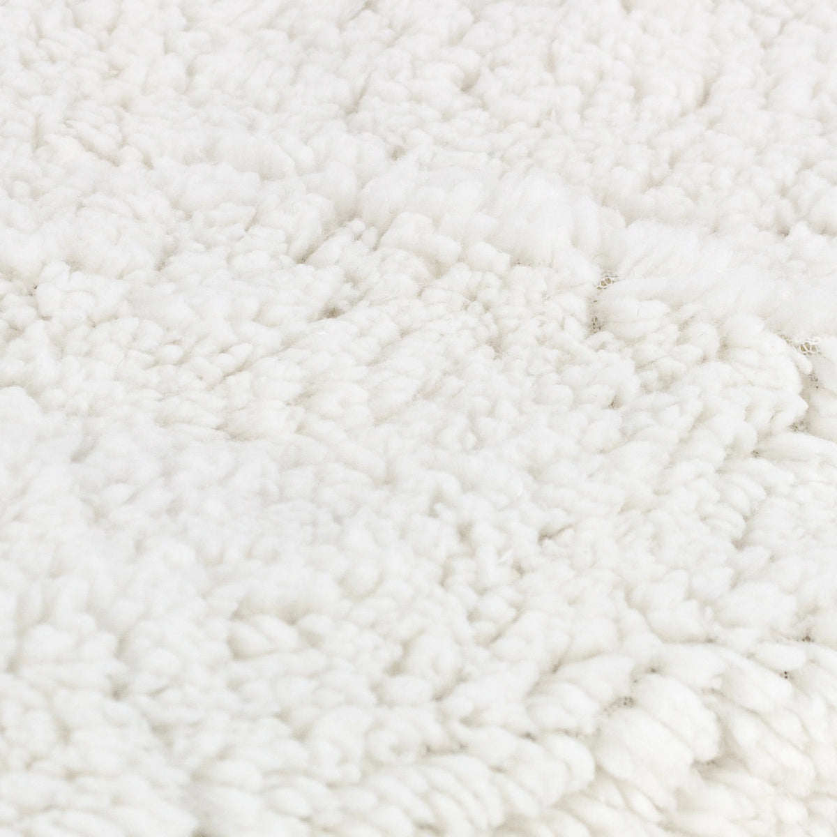 Close-up detail of the cream sherpa fleece texture showing its soft looped pile finish – Kumperi
