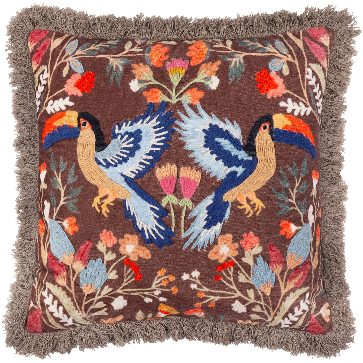 Square brown velvet cushion embroidered with two mirrored navy and pale blue toucans facing each other with wings outspread, surrounded by pink, orange and cream florals and foliage, finished with a grey fringe trim – Kumperi