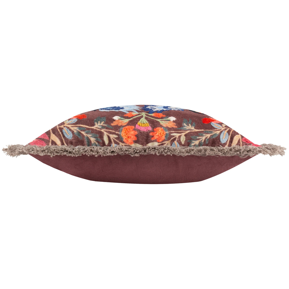 Side profile of the cushion showing the brown embroidered toucan and floral front meeting the plain burgundy velvet reverse, edged with a grey fringe trim – Kumperi