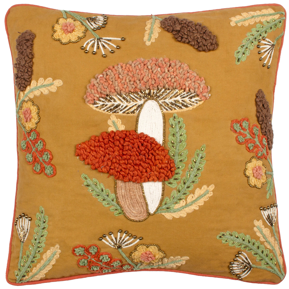 Square mustard gold cushion with raised embroidered toadstool mushrooms in dusky pink and burnt orange with beaded gold gills, surrounded by green ferns, yellow beaded flowers, brown pom-pom pussy willow and dandelion seed head motifs, finished with a burnt orange piped edge – Kumperi