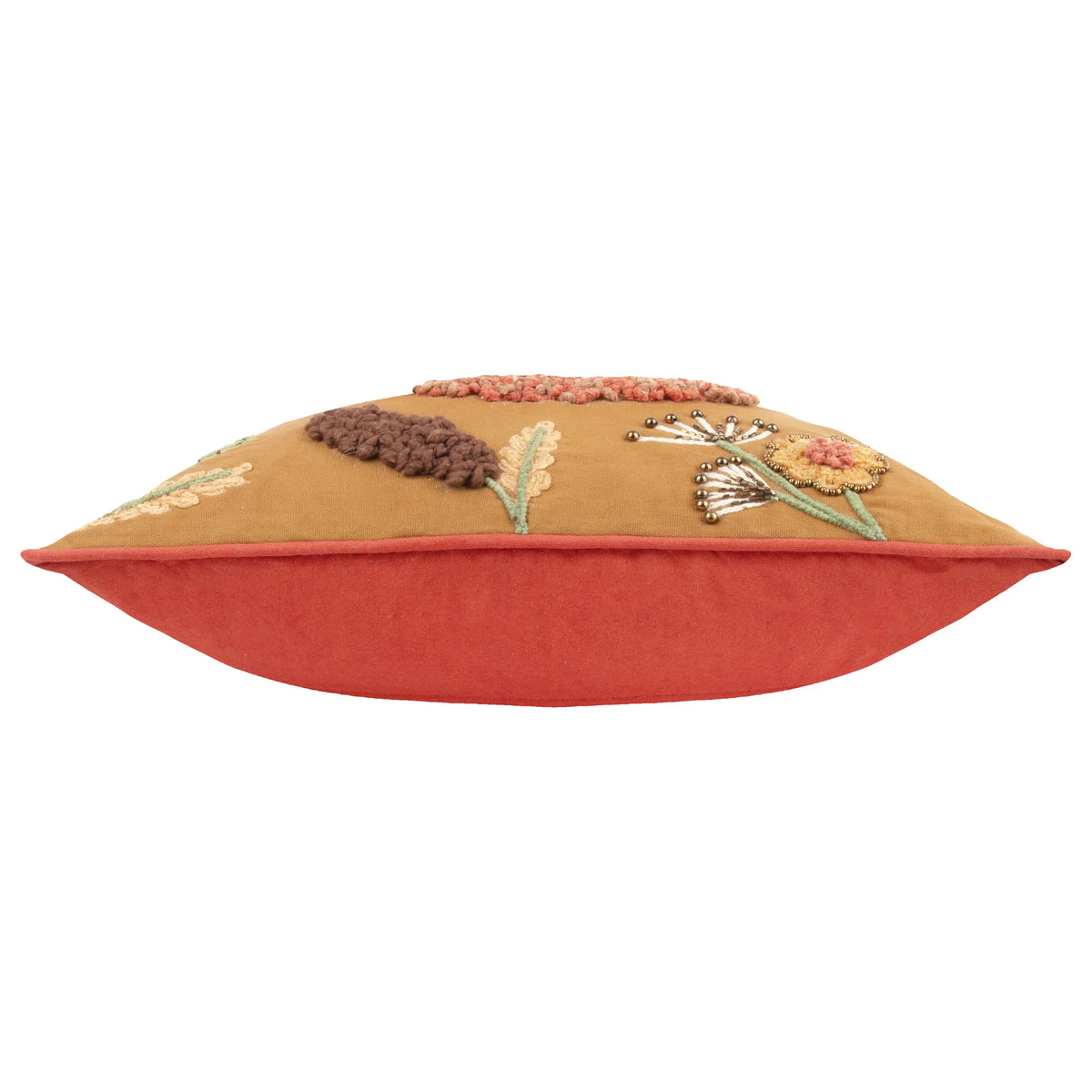 Side profile of the cushion showing the mustard gold embroidered front with beaded dandelion seed heads and a flower, meeting the plain burnt orange reverse along a piped seam – Kumperi