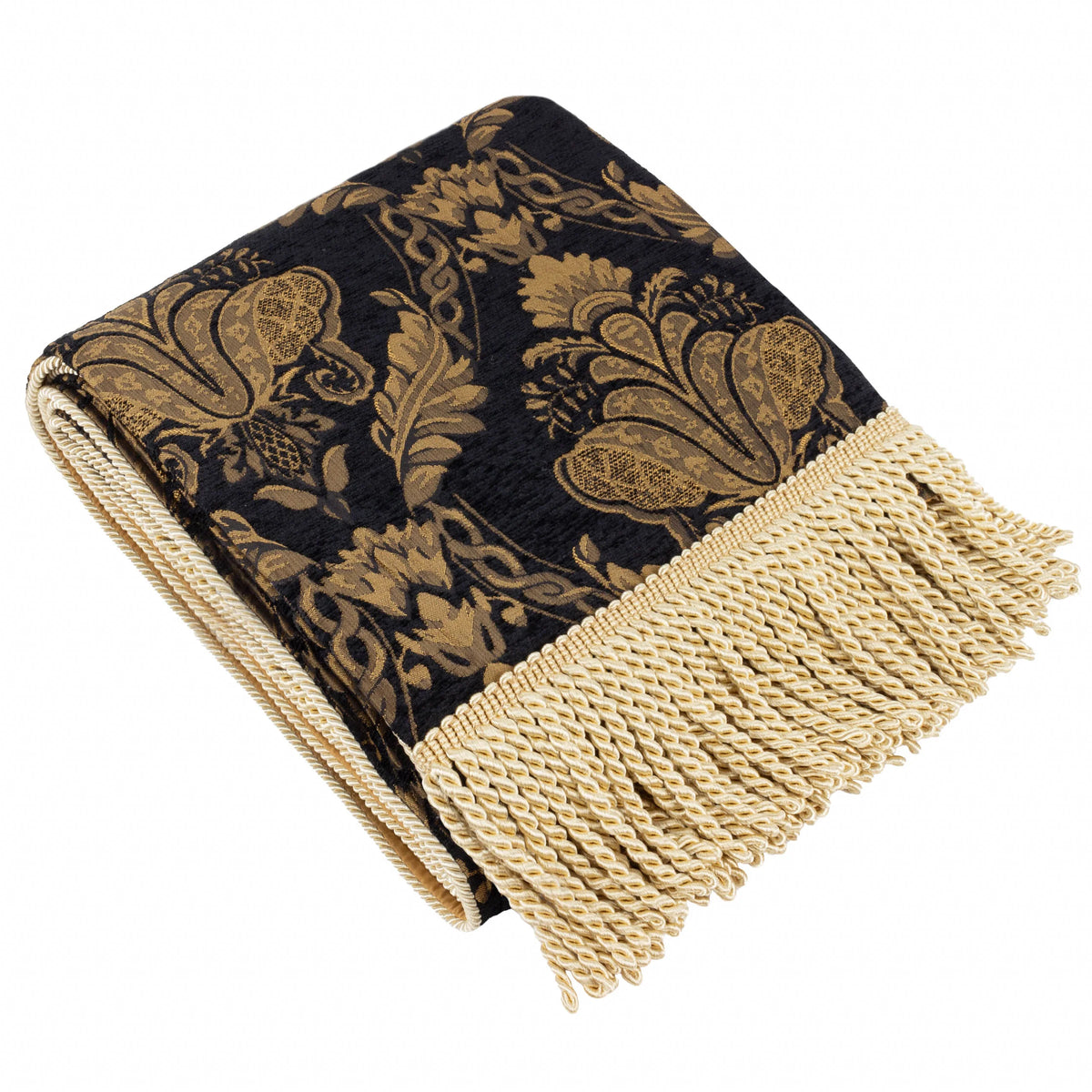 Folded black jacquard throw showing an ornate golden damask pattern of florals and scrolling foliage, finished with a cream fringed trim along the edge – Kumperi