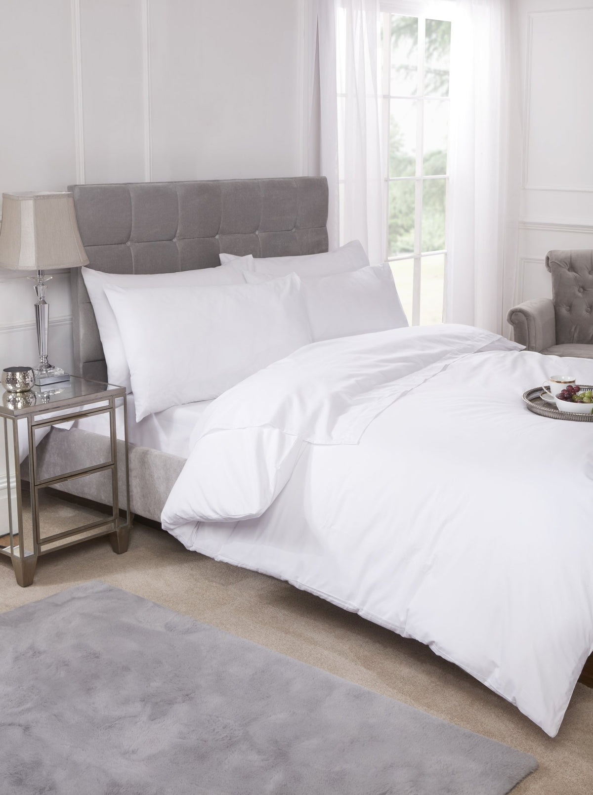 White percale flat sheet neatly dressed on a bed with a crisp smooth finish