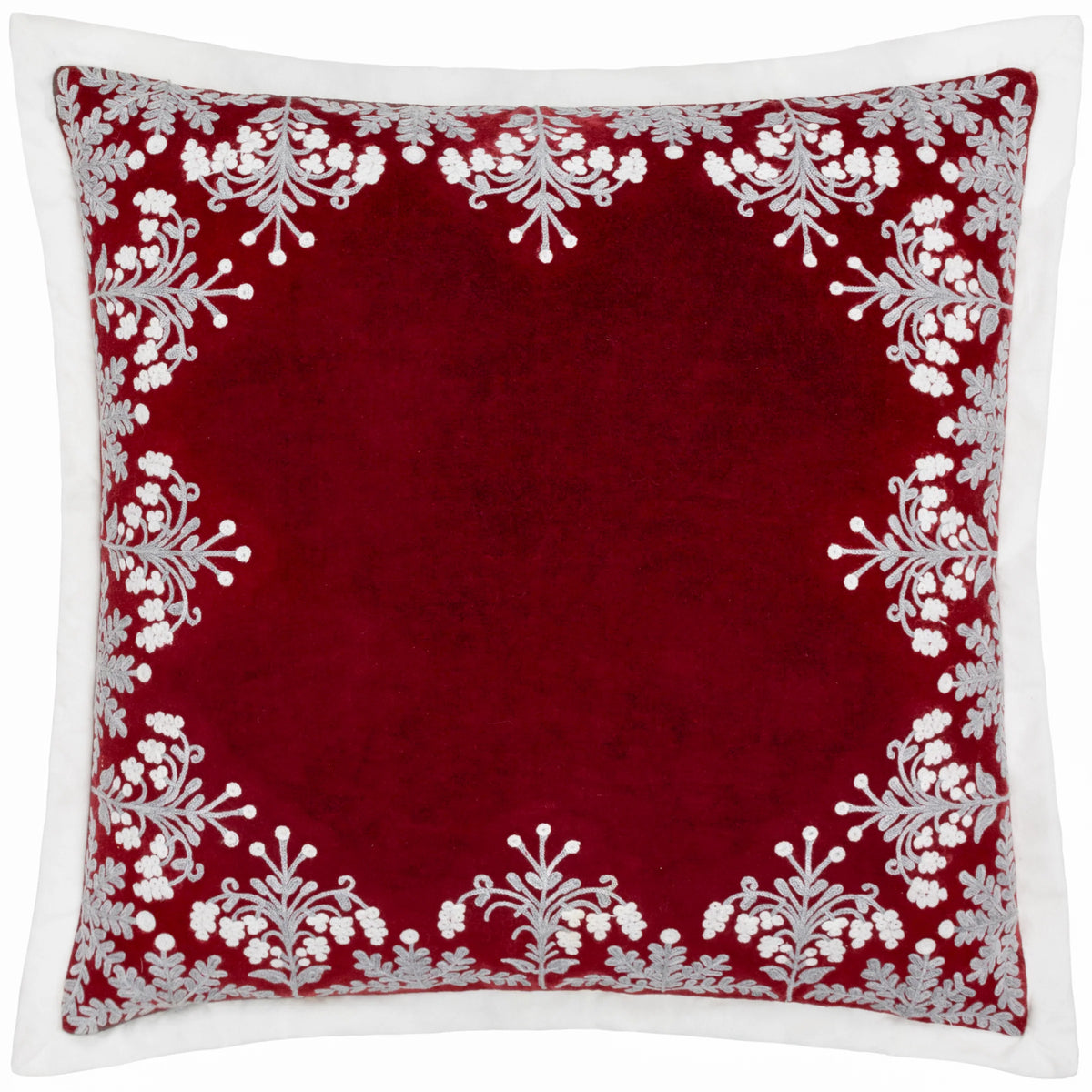 Square red velvet cushion with an embroidered border of grey and white berry sprigs, ferns and floral clusters framing a plain red centre, finished with a white Oxford edge – Kumperi